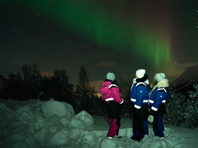 Gjester ser på nordlyset som viste seg bak dem