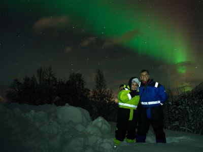 Gjester poserer foran nordlyset