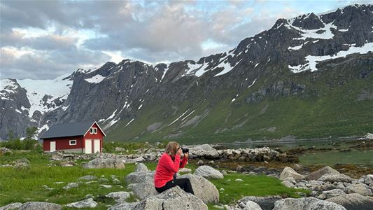 A person taking pictures with the mountains in the back