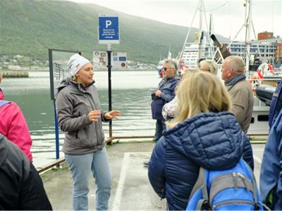 Guide fra Arctic Guide Service forteller om Tromsøs historie under en guidet byvandring i sentrum.