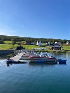Rental boats at the marina at Larseng Kystferie, with the coastal landscape of Kvaløya in the background.