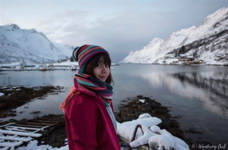 A guest enjoying views of the fjord and snow-covered mountains on a winter tour in the Tromsø region.