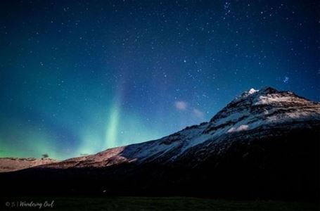 Night sky and northern lights behind mountains