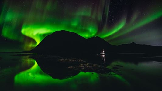 The Northern Lights reflected in the sea at Gjøssøy.