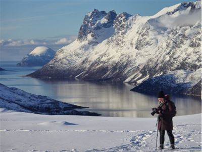 A guest enjoys views across the fjord and surrounding mountains in winter.