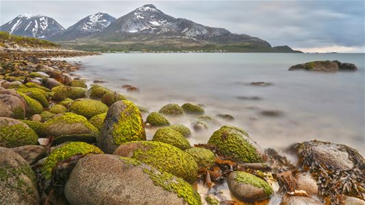 Mountains, sea and rocky coastline in the scenic landscape of Kvaløya outside Tromsø.