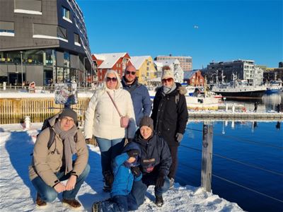 En gruppe gjester som poserer Gjester på guidet byvandring i Tromsø sentrum