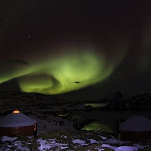 Northern lights over small huts