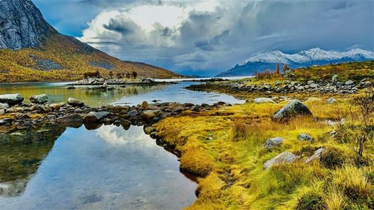 Mountains, water and autumn colours in the Arctic landscape of the Tromsø region.