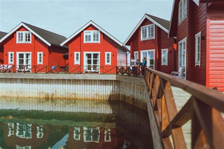 Flere røde rorbuer ved sjøen