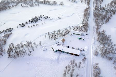 Aerial view of the husky camp surrounded by the snowy landscape of Breivikeidet.