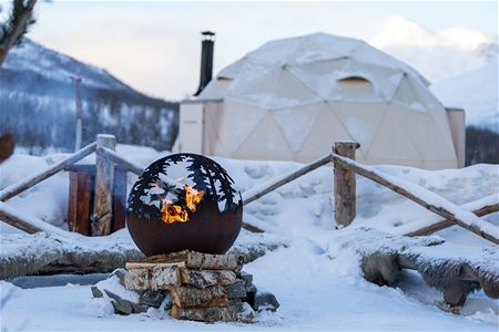 Fire pit in the snow-covered camp area at Camp Tamok