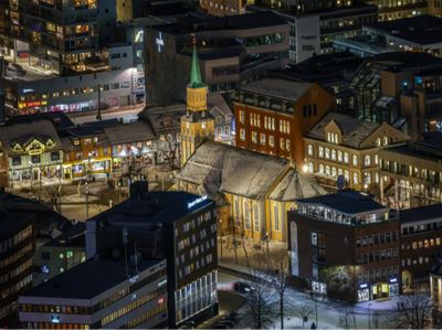 Utsikt over Tromsø sentrum på kveldstid, en del av området som utforskes på den historiske byvandringen.
