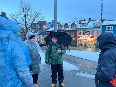 Deltakere på en guidet byvandring gjennom Tromsø sentrum med fokus på lokal historie, samisk kultur og mytologi.
