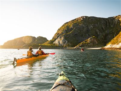 Guided kayaking along the rocky coastline of Sommarøy