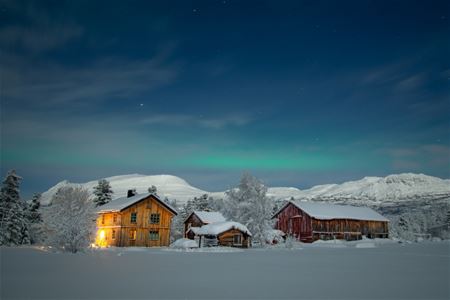 The private lodge at OffTrack Experience surrounded by the winter landscape of Målselv.