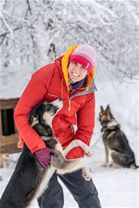 A guest spends time with one of the Alaskan huskies at the family-run husky farm.
