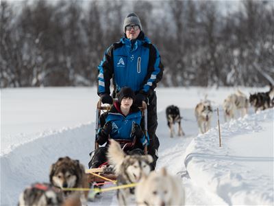En gjest kjører sitt eget hundespann gjennom snøen.