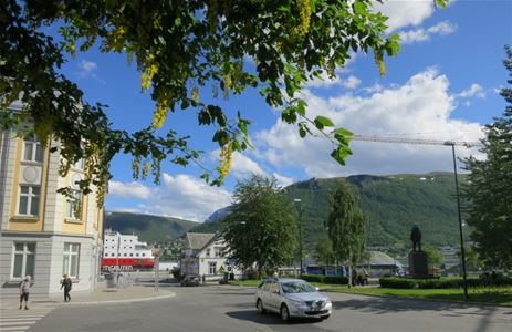 Gatebilde med historiske bygninger og fjellutsikt i Tromsø sentrum.