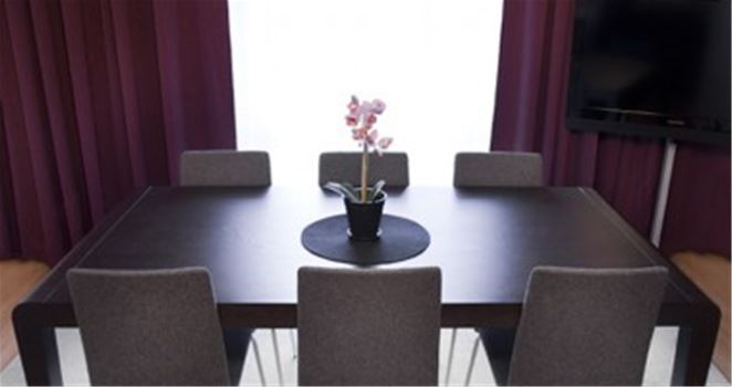 Ett konferensrum med ett bord och ett par stolar