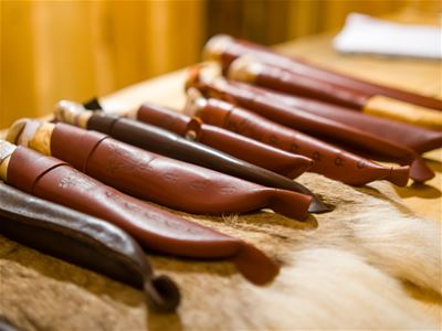 Tradisjonelt samisk håndverk og kniver presentert som en del av en kulturell opplevelse i Tromsø.