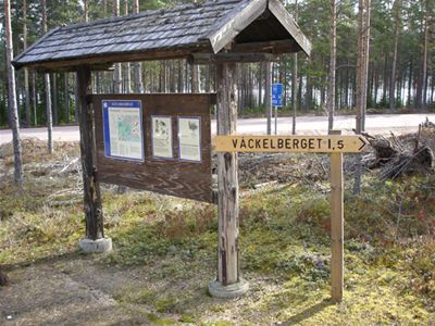 Informationstavla, träskylt med texten Våckelberget.