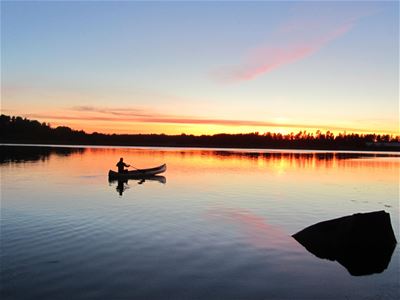 Man in canoe during sunset.