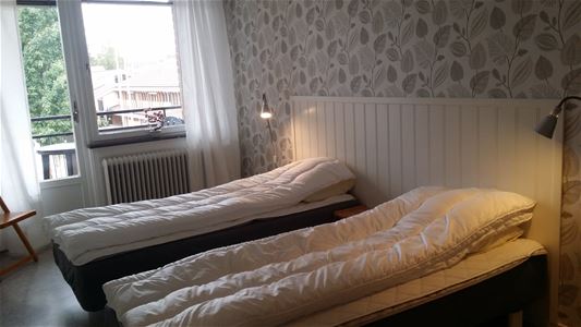 Sovrum med två enkelsängar och balkong.