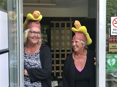 Two women, each with a hot dog hat on their heads