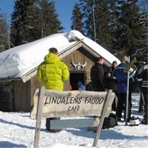 People who are on their way into the waffle house. Winter. Sign in front where it says Lindalen's summer pasture.