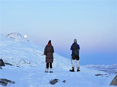 Guests snowshoeing through a snowy mountain landscape during a winter tour with Legendary Adventure.